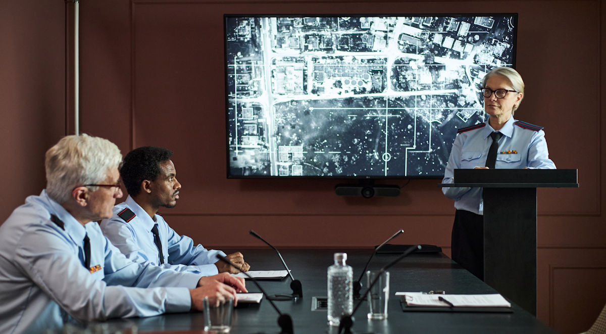 people in uniform in front of screen